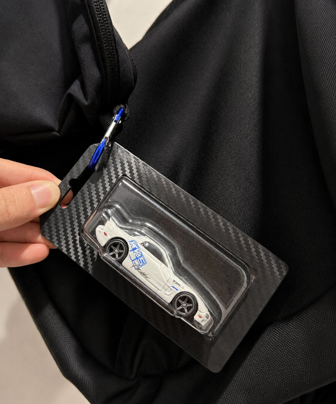 Premium black blister key chain clipped to a bag
